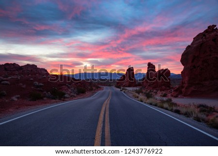 Scenic view on the road in the desert during a dramatic sunrise. Taken in Valley of Fire State Park, Nevada, United States.
