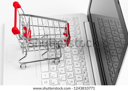shopping online concept. small toy trolley and gadgets on the table