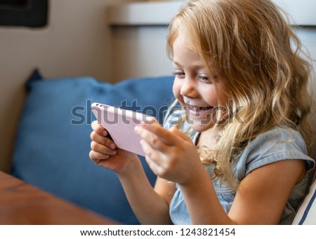 Little girl watching a movie on her phone