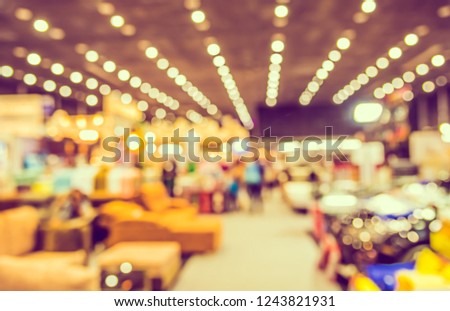 Vintage tone Abstract blur image of Furniture expo in hall with bokeh for background usage .