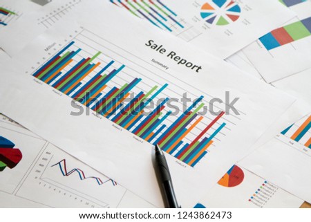 Sheet of graphs on a table with black pen shows sale report. Business concept Royalty-Free Stock Photo #1243862473