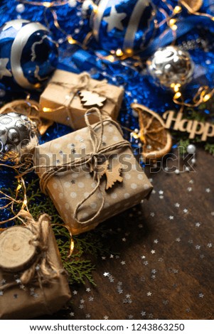 Blue christmas. gift in craft wrapping paper, ribbon, christmas balls. presents on dark wooden table 