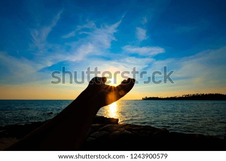Beautiful sunlight over hand silhouette in sunset use for holiday trip background
