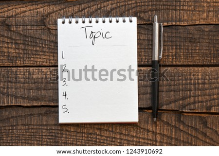 Topic text written in a notebook. High quality photo.