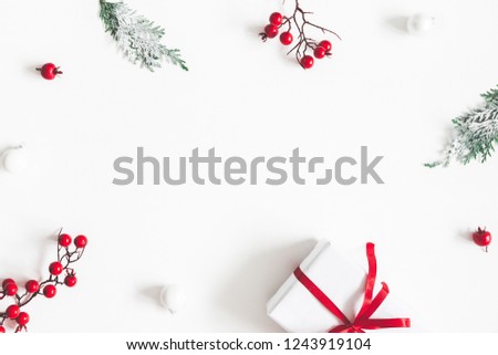 Christmas composition. Frame made of gift, snowflakes, fir tree branches and red berries on white background. Christmas, winter, new year concept. Flat lay, top view, copy space