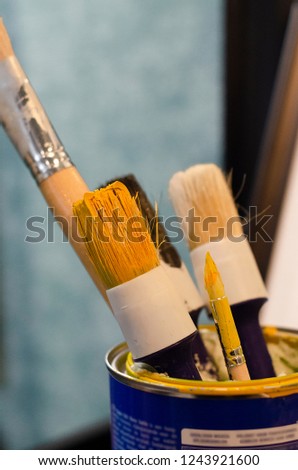 paint brushes are in a can of paint