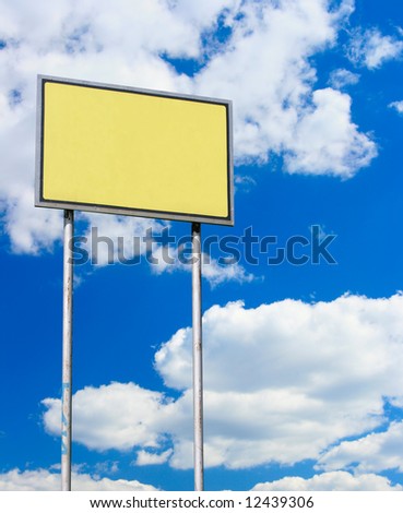 Yellow blank sign against blue sky with clouds