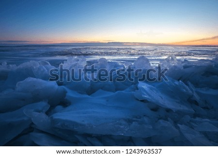 Beautiful winter landscape with sunset sky and frozen lake. Composition of nature.
