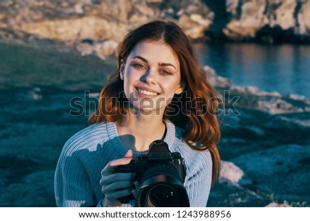 The first red-haired woman with a camera in nature                               