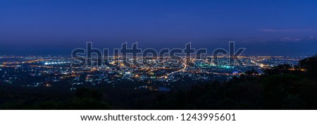 Panorama landscape photo of big city with twilight blue sky before night time.Skyline form Doi Suthep cityscape scenic point at Chiang mai ,Thailand.Evening scene of city.Scenic area of Chiang Mai.