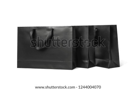 Paper shopping bags with ribbon handles on white background. Mockup for design