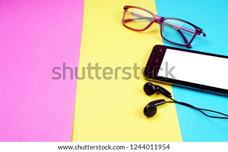 Top view of colorful working table have Headphones,mobile phone on color blue, Yellow and pink background for create idea for business or design. Relax time listen song (flat lay).