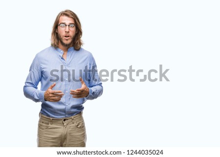 Young handsome man with long hair wearing glasses over isolated background afraid and shocked with surprise expression, fear and excited face.
