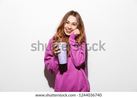 Portrait of adorable woman 20s wearing sweatshirt drinking soda from paper cup using straw isolated over white background