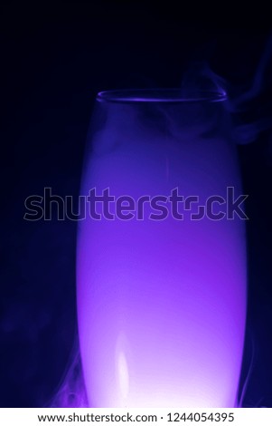 purple smoke (evaporation) in a glass dish on a black background