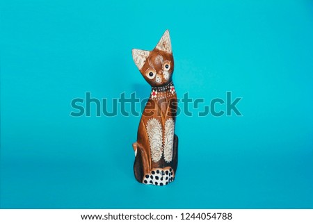  wooden brown cat souvenirs sit on a blue background

