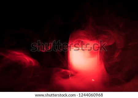 red smoke (evaporation) in a glass bowl on a black background