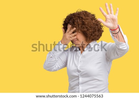 Beautiful middle ager senior businees woman over isolated background covering eyes with hands and doing stop gesture with sad and fear expression. Embarrassed and negative concept.