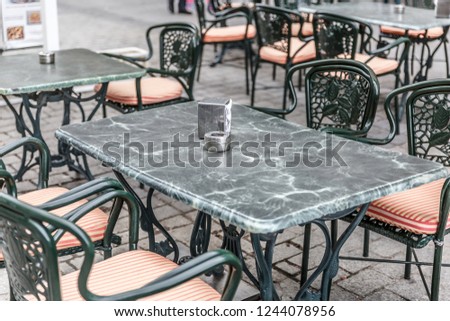 Typical tables and chairs outside a bar in Madrid, with napkins and ashtray, Spain