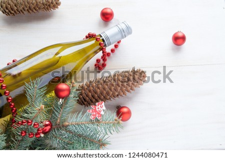 bottle of wine near christmas tree new year toys on white wooden background