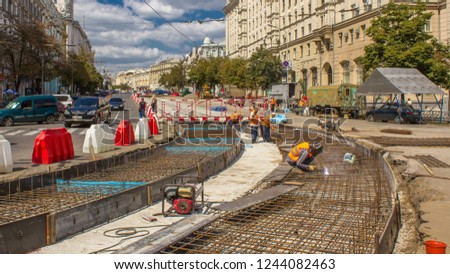 Workers with protective mask welding reinforcement for tram tracks in the city road construction timelapse. Reconstruction of tram tracks.