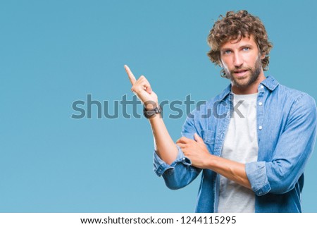 Handsome hispanic model man over isolated background with a big smile on face, pointing with hand and finger to the side looking at the camera.
