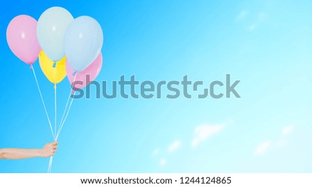 hand hold balloons on blurred sky background,copy space, holidays,celebration