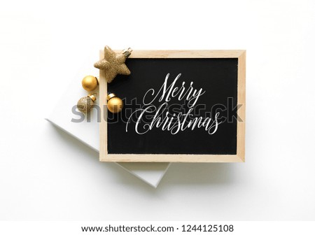 Christmas tree gold decoration flat lay, top view on white background. Black board sign Merry Christmas text