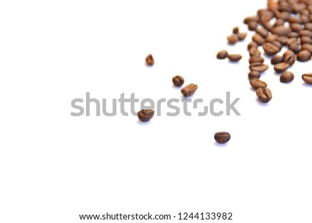 Coffee beans lie on a white surface and protrude into the picture - white background with coffee beans on it and space for text or other elements