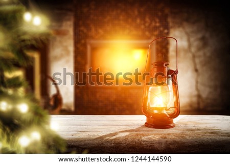 Wooden table with fireplace and christmas tree with lamps. Free space for your decoration. 