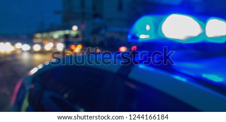 Unrecognizable blurry police car lights on night street background, crime scene, night patrolling the city. Abstract  defocused image. 