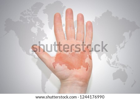 hand with map of russia on the gray world map background. concept