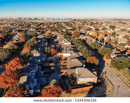 Top view planned unit development suburbs of Dallas, Texas, USA in autumn season. Picture from drone residential area with colorful fall foliage leaves under blue sky
