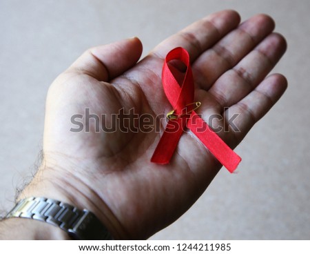 World Aids Day concept consisting of a hand and red ribbon. 