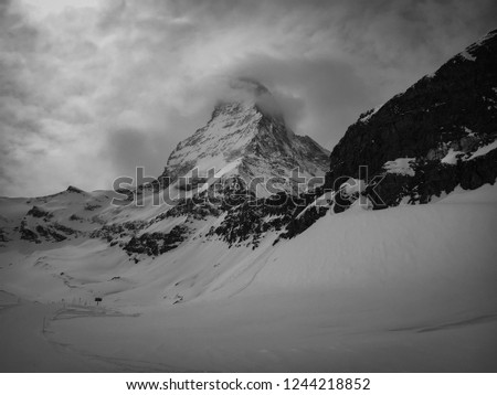 Dramatic black and white picture of Matterhorn mountain wrapped in clouds