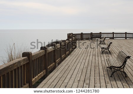 Wooden esplanade on the sea shore with benches to relax in Retamar Almería