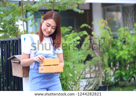 young woman hand holding brown parcel box at the home, shipping and postal service concept