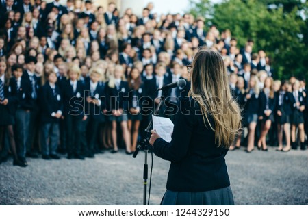 Head girl gives a speech to students at a boarding school Royalty-Free Stock Photo #1244329150