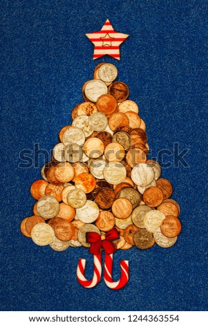 Christmas tree with American coins with red bow, star, candy cane on blue denim background, copy space, text place, top view. Merry Christmas card print for rich and poor