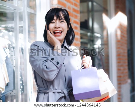 Happy Asian woman shopping at outlet mall,She's joyful with end of Season winter sale.