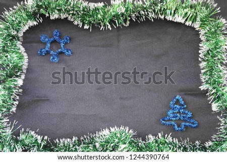 Black background for your text in a green festive frame and with a blue asterisk and Christmas tree. Christmas background.