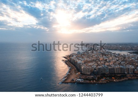 Photo shows cloudy sunrise with reflection on the sea water at Malta.