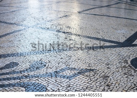 Floor tiles on a public street in Lisbon,Portugal.Old stone paved street.Cobblestone road pavement texture.White tone stone walkway abstract background.