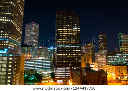 illuminated city lights in Denver , Colorado , USA at Night Downtown City glowing Nightscape Skyline of the Mile High City Skyscrapers and office buildings rising up into the night sky cityscape