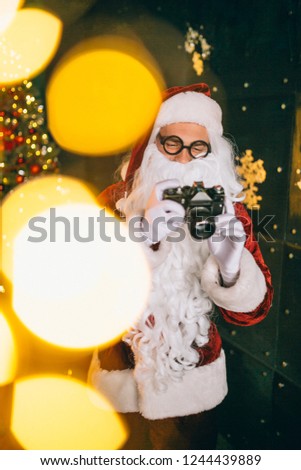 Santa claus making photos on camera