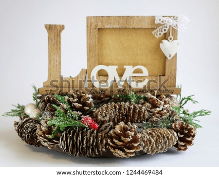 Christmas frame for a photo with a Christmas wreath, a frame for a photo with Christmas-tree cones and snow. Photoframe love. Golden snowflake