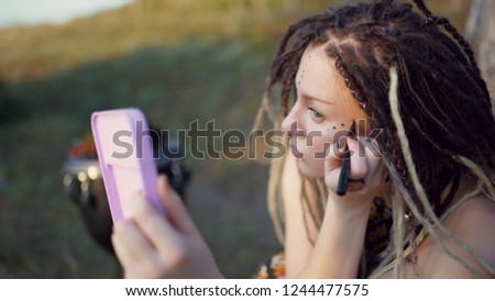 portrait of an attractive hippie woman with dreadlocks in the woods at sunset having good time outdoors