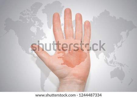 hand with map of iceland on the gray world map background. concept