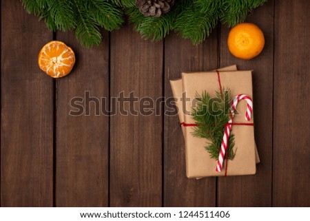Top view of Holiday gifts wrapped with eco friendly craft paper and tied with twine decorated with candy cane on a rustic dark wooden table. Space for text. Christmas concept. New Year concept. Gifts