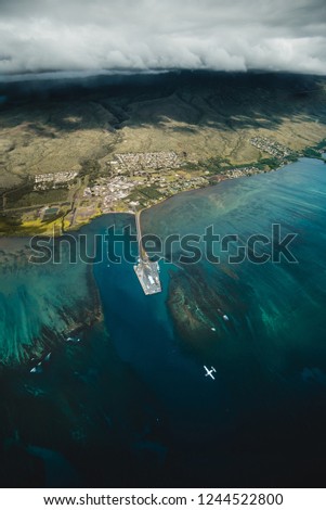 Beautiful Aerial View of Tropical Island Paradise Nature Scene of Molokai Hawaii with Airplane Below and Vibrant Blue Ocean Water and Waves and Lush Green Mountain Scenic Landscape 